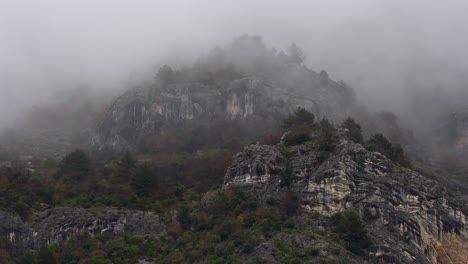 Nebliger-Tag-In-Den-Felsigen-Bergen,-Umhüllte-Kiefern,-Unheimlicher-Nebel,-Der-Die-Landschaft-Mit-Kälte-Und-Geheimnis-Bedeckt