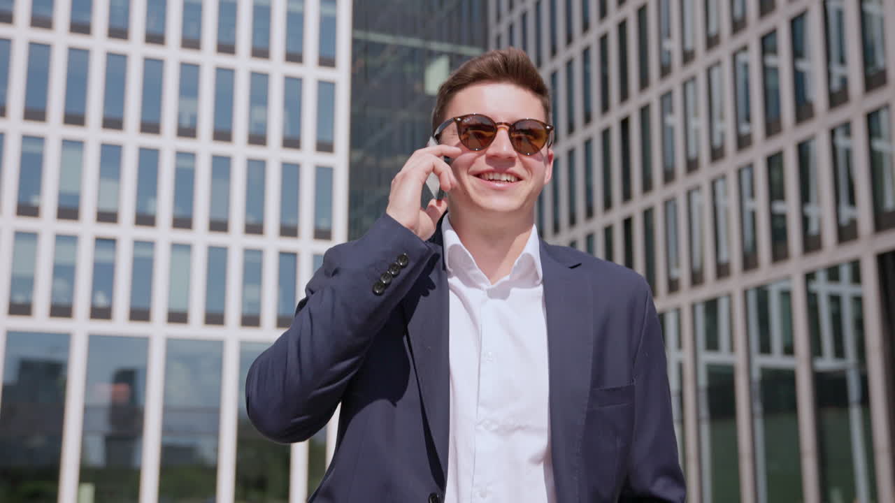 젊은 성공적인 기업가가 비즈니스 디스트릭트 도리  ⁇ 에서 전화로 이야기합니다.