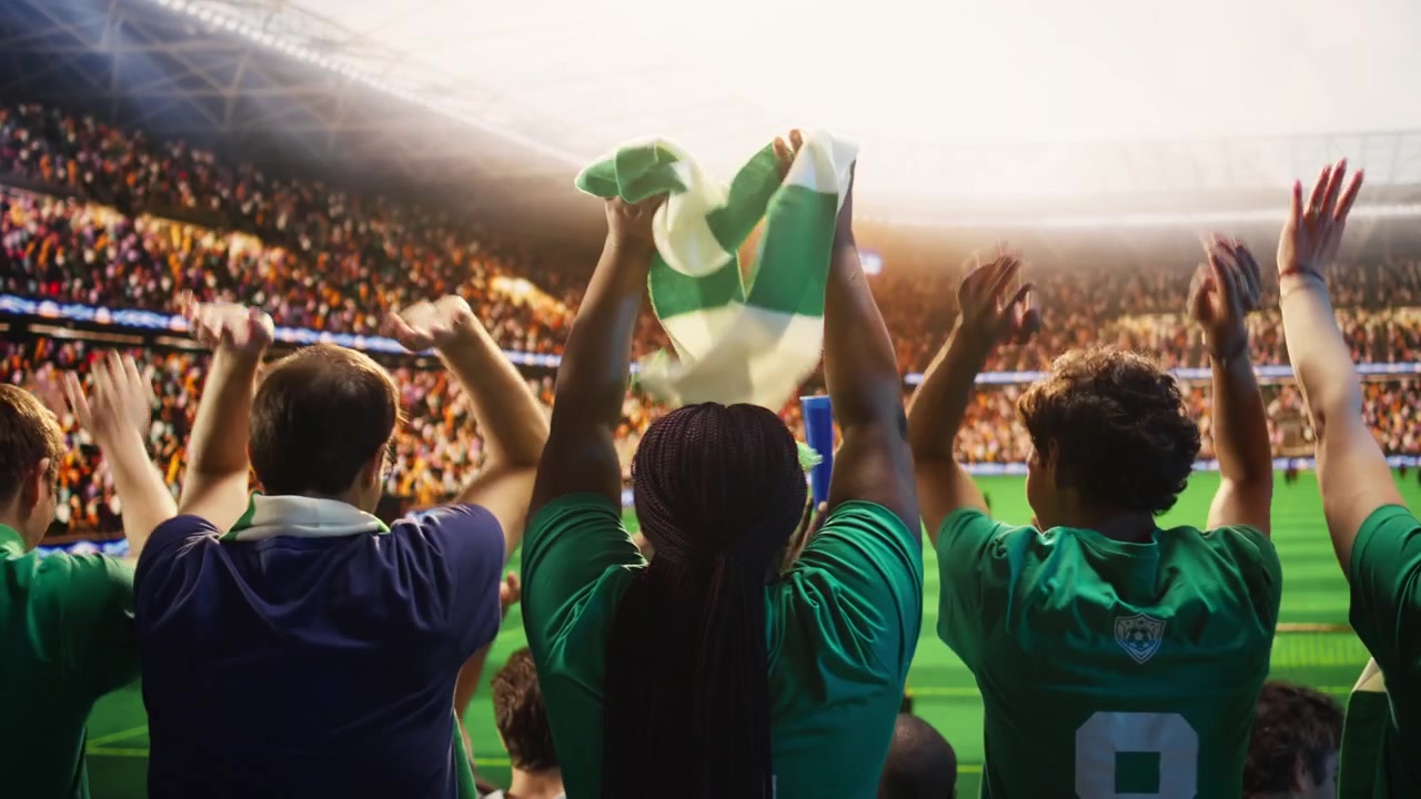 Primer plano de aficionados al fútbol levantando las manos juntos, haciendo la ola