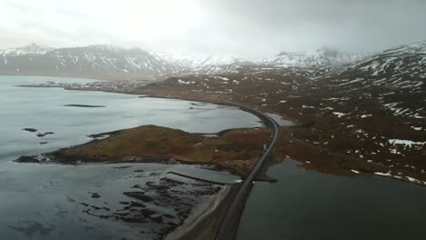 4k drone footage captures the unique beauty of a lake and rocky mountain in iceland amidst challenging weather conditions