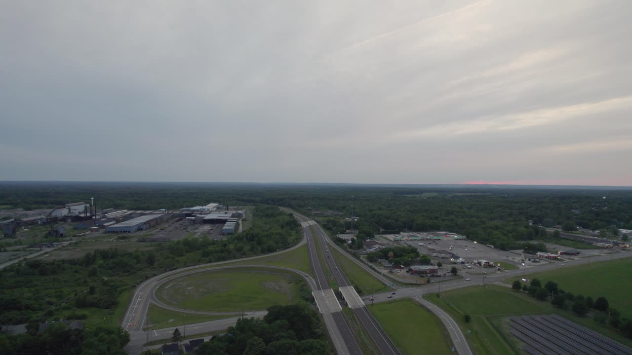 고속도로 양쪽에 무성한 푸른 나무가 있는 일몰의 공중 전망