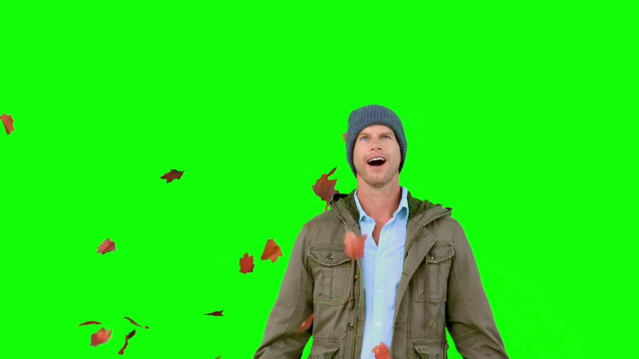 Amazed man looking at falling leaves on green screen