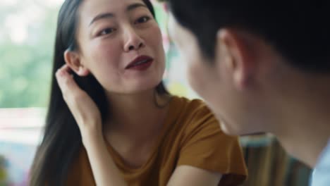 handheld view of vietnamese couple talking at cafe