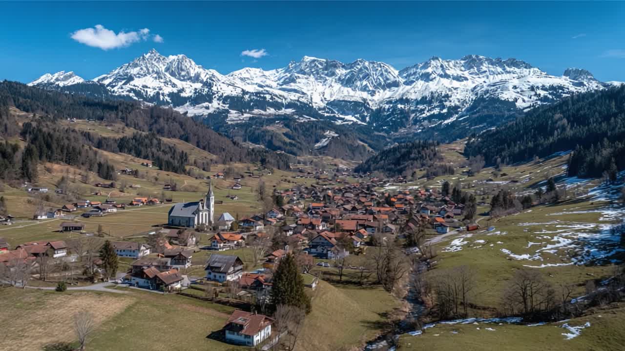 Breathtaking Aerial View of a Serene Village Surrounded by Majestic Snow-Capped Mountains in the Heart of Nature's Splendor