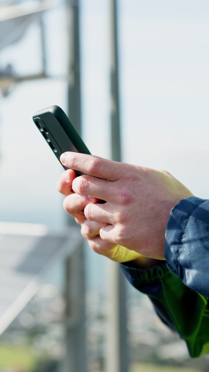 Tecnico che utilizza uno smartphone vicino a un impianto di pannelli solari