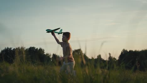 Little-boy-running-with-toy-airplane-at-meadow.