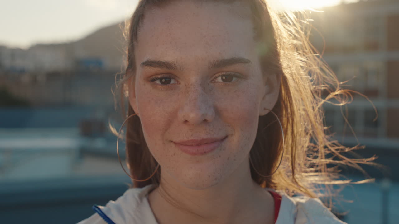 портрет красивой девушки-подростка, улыбающейся, выглядящей счастливой от ветра, рыжеволосой женщиной, наслаждающейся позитивным самооценкой в городе на закате