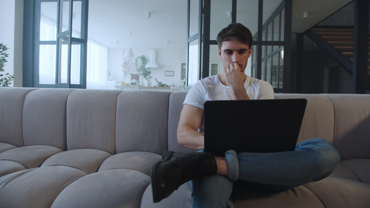 hombre centrado trabajando en una computadora en un lugar de trabajo remoto en cámara lenta.