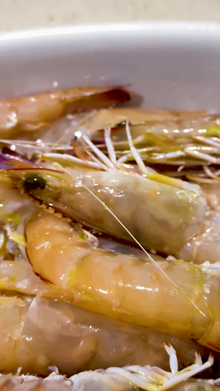 손으로 신선한 새우 위에 소금을 뿌리는 것