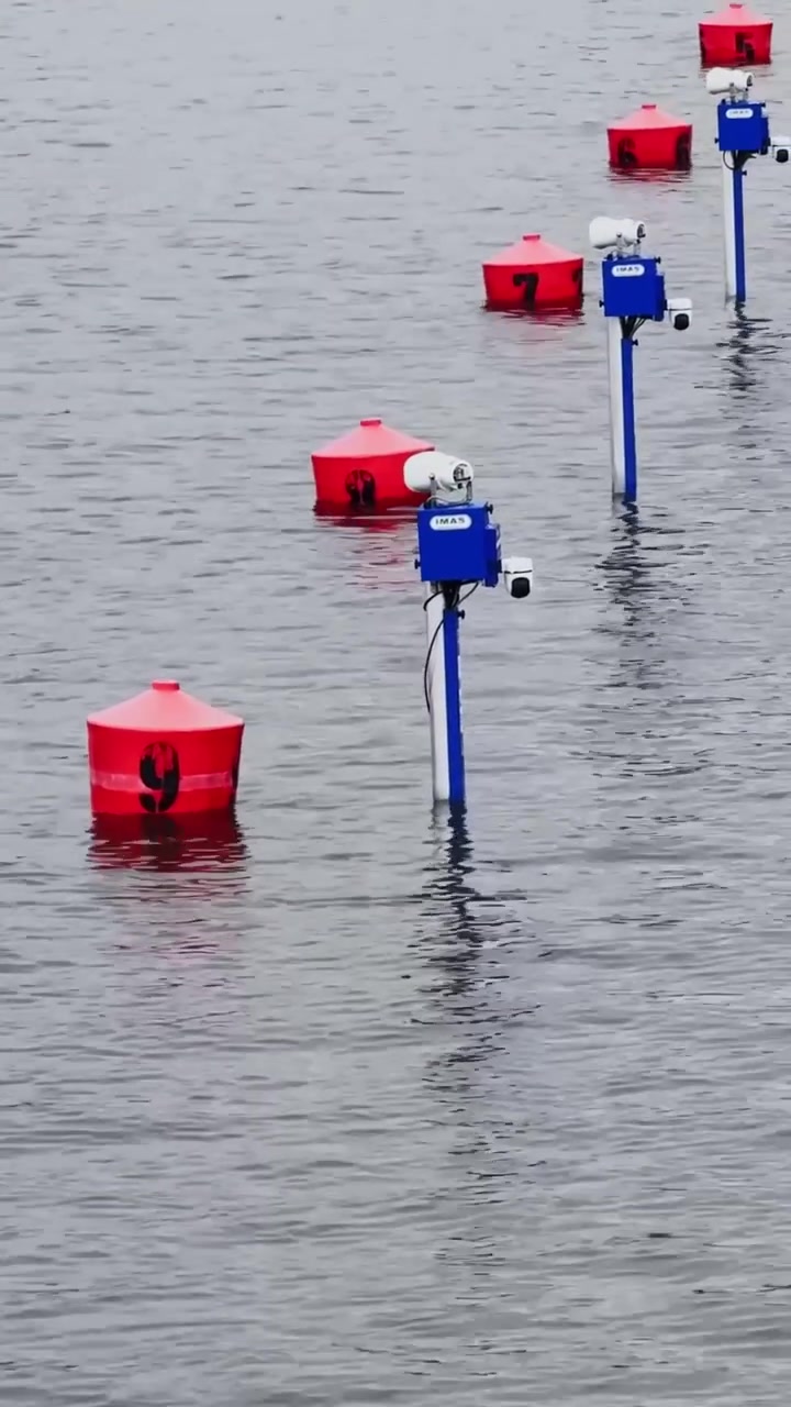 Red racing buoys and course marker float on Beetzsee water at Brandenburg canoe sprint venue, vertical tilt upward