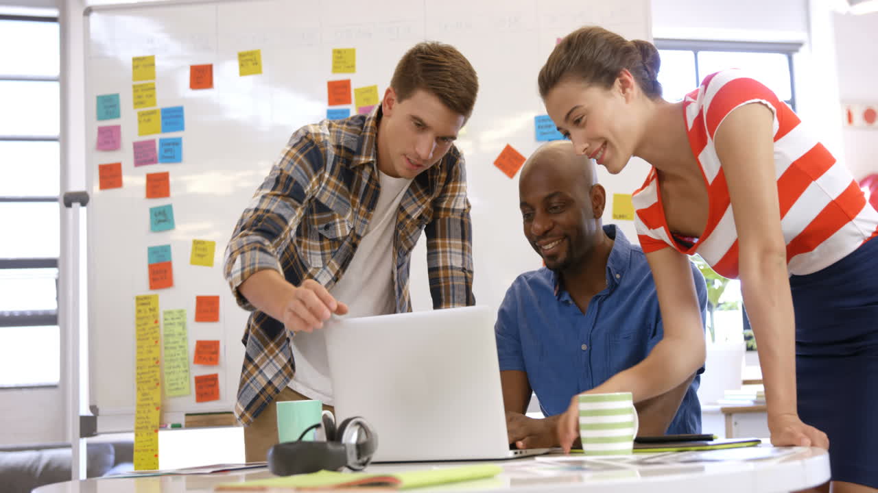 colegas ocasionales trabajando en una computadora portátil