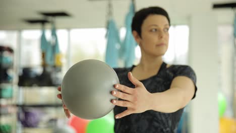 woman performing pilates exercise with ball