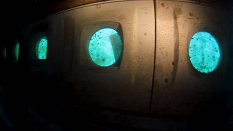 scuba divers searching through a plane wreck on the bottom of the ocean