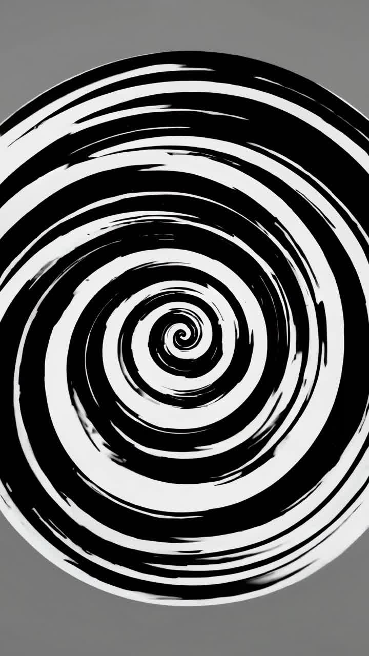 Aerial view of a black and white spiral pattern, creating a hypnotic, dynamic effect