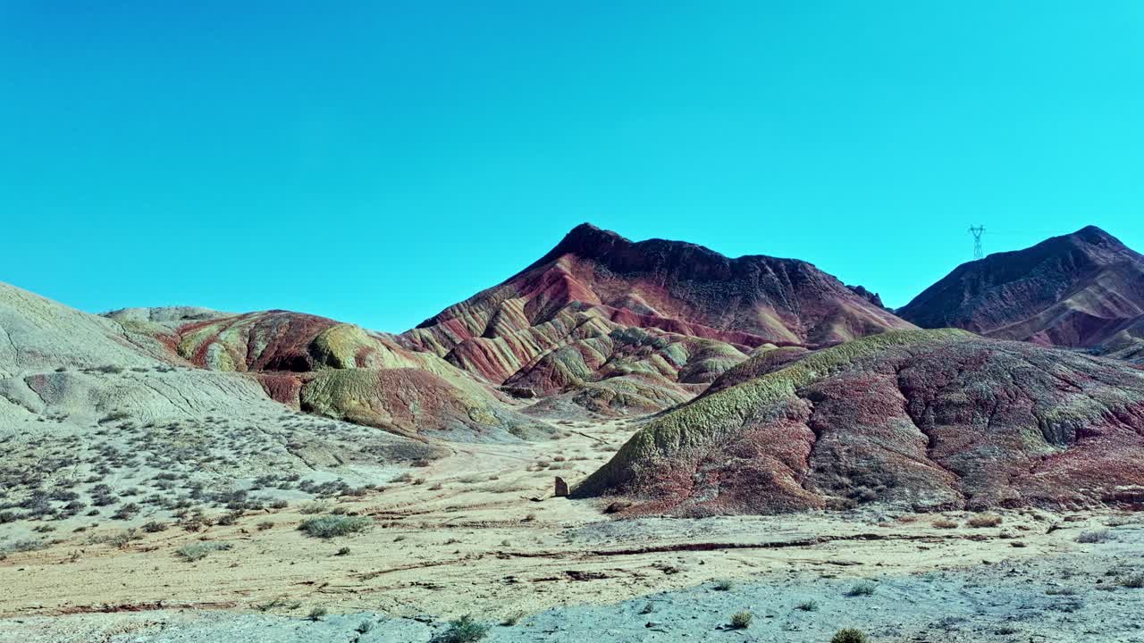 Zhangye, Gansu Province, China - Colorful Layered Hills Stretch Across a Dry Valley Under a Clear Blue Sky - Pan Shot