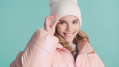 teenage caucasian girl with winter clothes making faces in front of the camera.