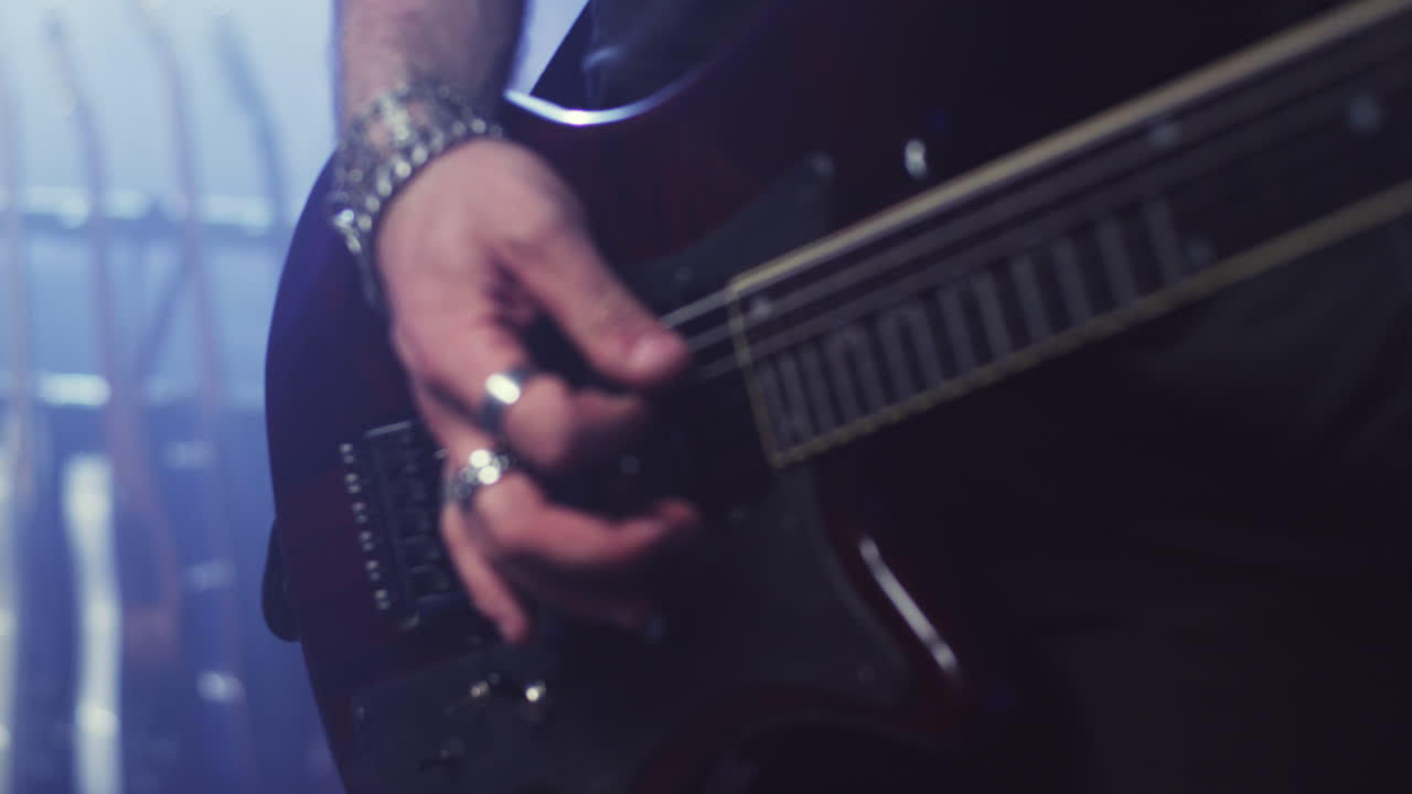 Uomo che suona la chitarra elettrica e l'accorda.