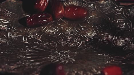 beautiful shiny dried dates roll one by one into a dish