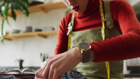 Caucasian-non-binary-transgender-woman-working-at-home,-sewing