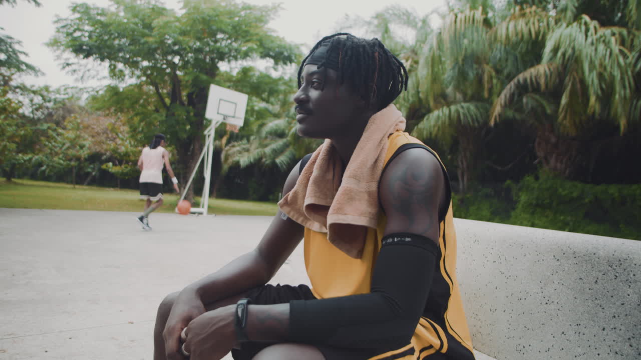 Portrait of Cheerful Black Streetball Player Resting on Bench