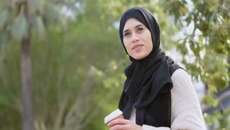 woman in hijab holding coffee cup 4k