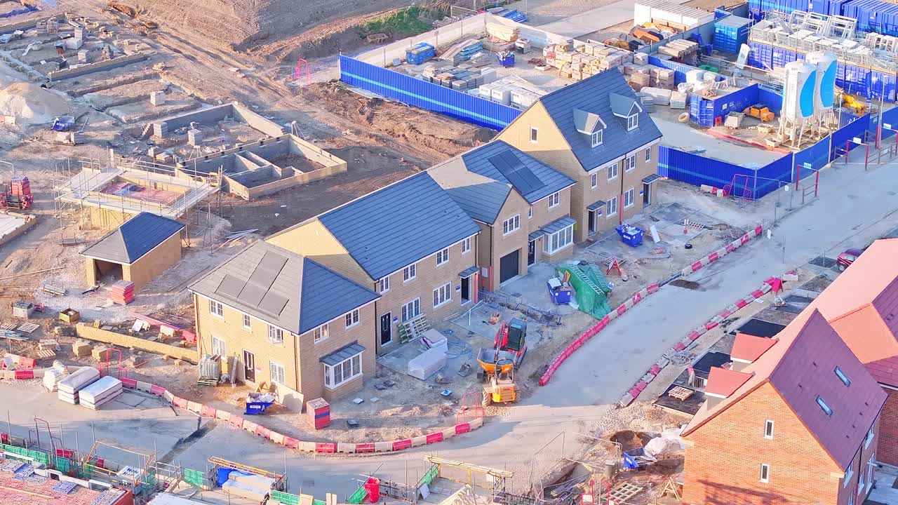 High-resolution static drone shot capturing newly built houses, construction materials, and active groundwork on a modern housing development site in Wombwell, South Yorkshire, England