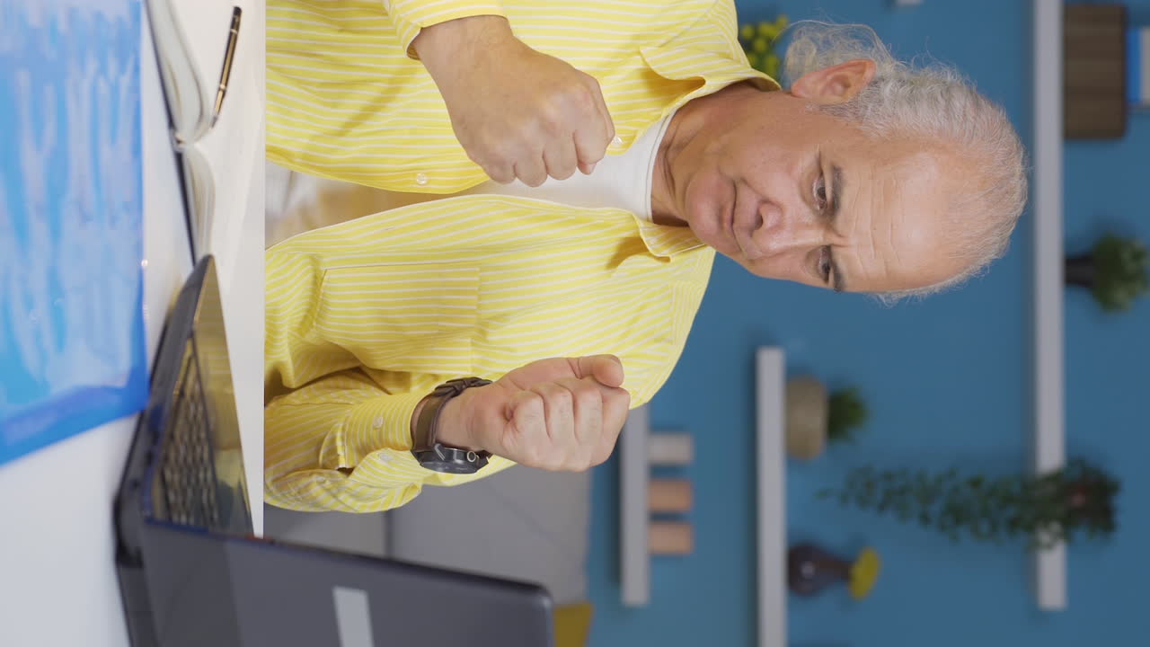 홈 오피스 직원의 수직 비디오는 그가 읽고 보는 것과 함께 그의 정신을 높입니다.