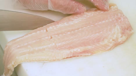 Nahaufnahme-Der-Hände-Des-Küchenchefs,-Die-Fischfleisch-Schneiden