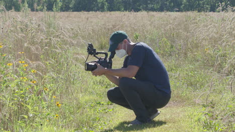 Ein-Mann-Mit-Einer-N95-chirurgischen-Maske-Filmt-Videoinhalte-Auf-Einem-Feld