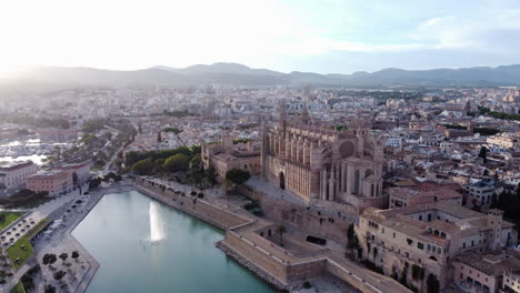 Aerial-above-Palma-de-Mallorca,-Santa-Maria-Cathedral-and-fountain,-sunset