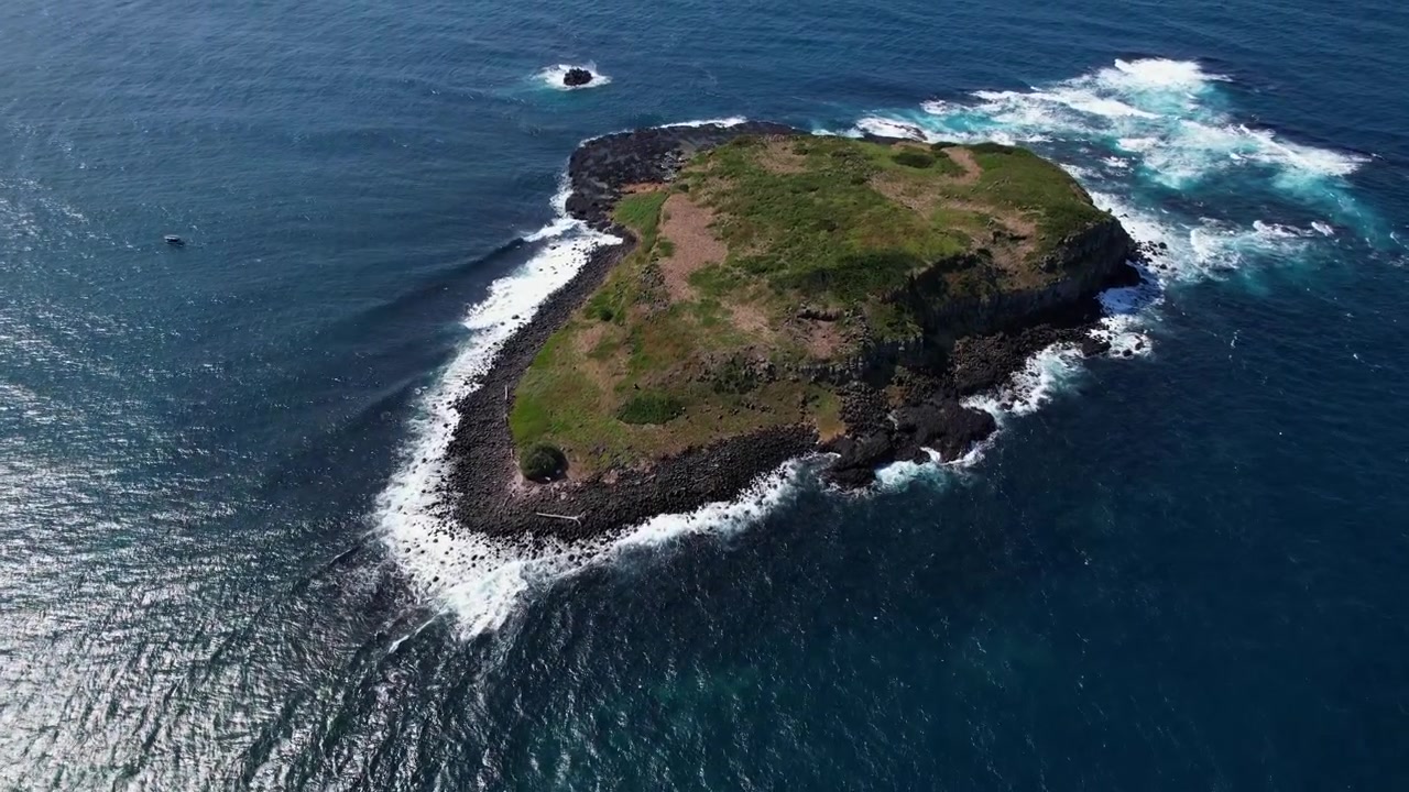 Isola di Cook con onde oceaniche su una costa rocciosa nel Nuovo Galles del Sud, Australia - Ripresa aerea
