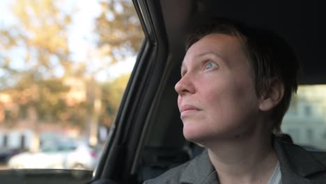 worried businesswoman waiting in the car and looking out the window