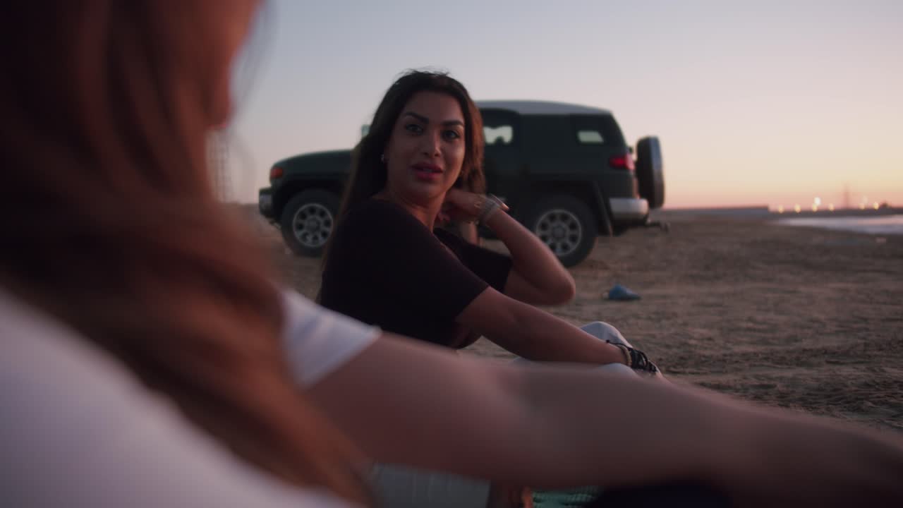 Two friends enjoying a sunset on the beach