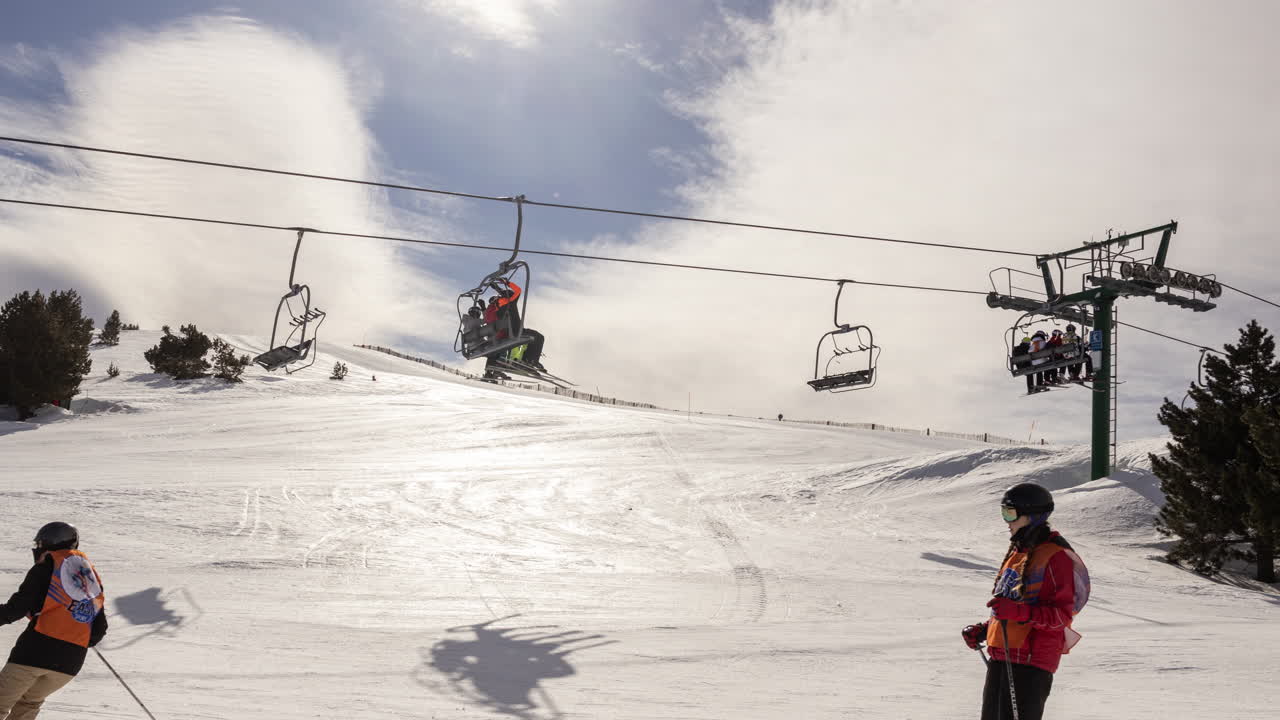 People Riding Ski Lift and Skiing Down a Snowy Mountain Slope