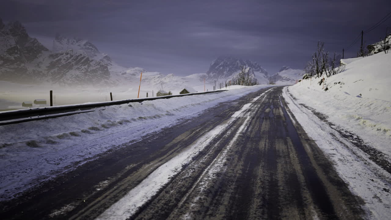 Winter road in a snowy landscape with mountains in the background