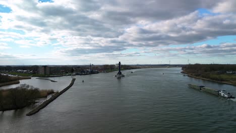 traffic in the canal "oude maas" with boats navigating through it, industrial vessels with crane