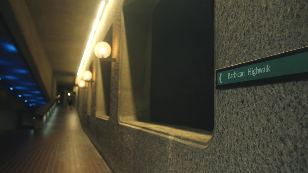 Nighttime static establishing of Barbican walkway, concrete texture lit by ambient architectural light