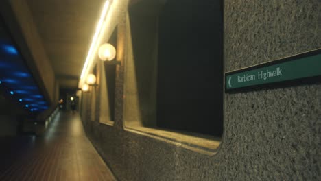 nighttime static establishing of barbican walkway, concrete texture lit by ambient architectural light