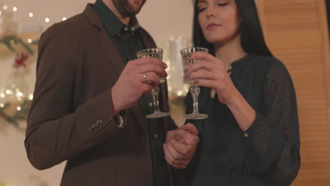 Loving-Couple-Toasting-And-Looking-To-Each-Other-At-Home-On-Christmas