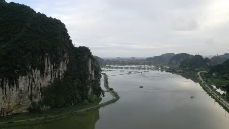 beautiful aerial shot of a lake in the green and lush mountains in asia on an cloudy day