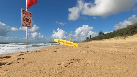 establecimiento de una toma de una playa australiana vacía con banderas de advertencia de surf