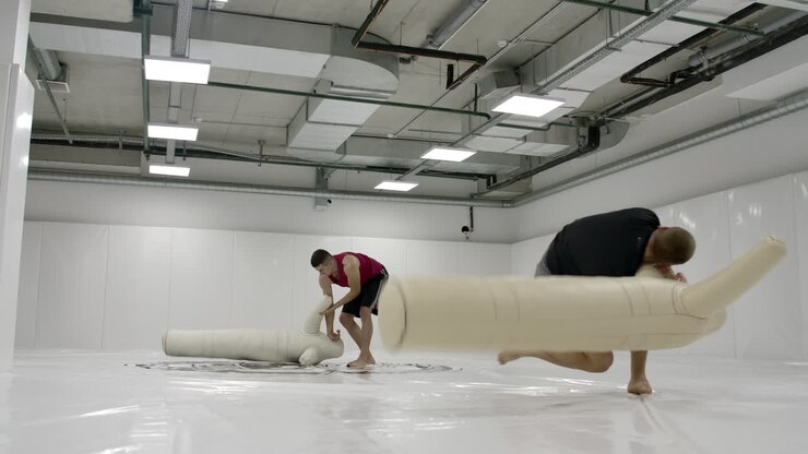 Due lottatori uomini eseguono una proiezione di allenamento sui tappeti al rallentatore. Lottatori professionisti di grappling.