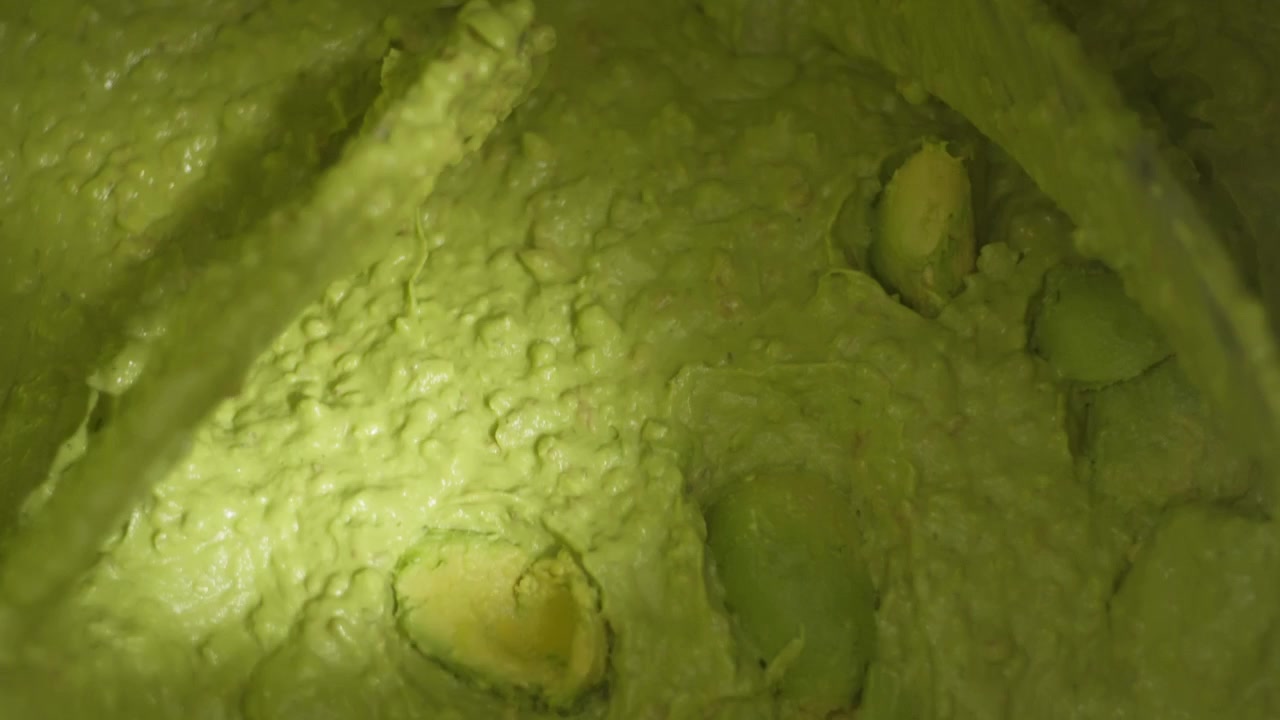 Nærbillede af cremet avocadotekstur, der blendes til en jævn pasta under produktion.