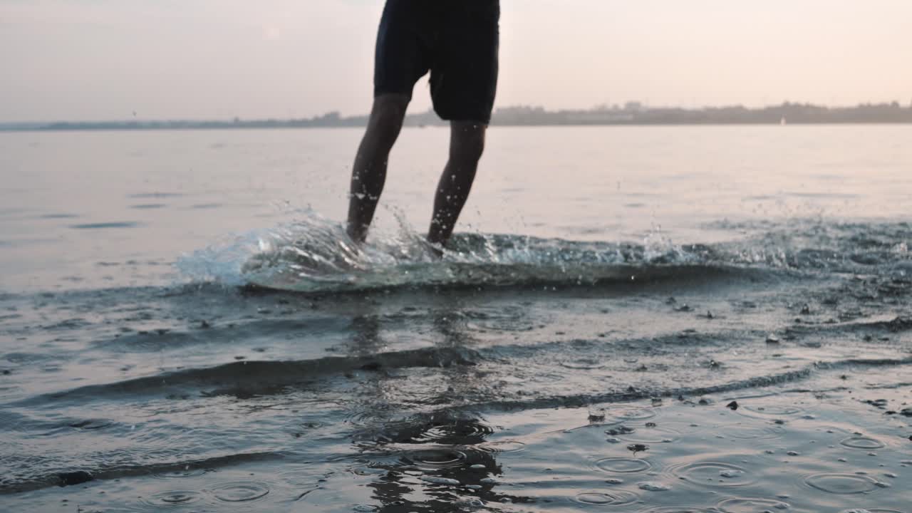 hombre surfeando en una playa durante la puesta de sol
