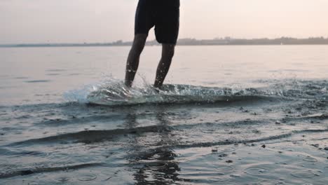 Hombre-Surfeando-En-Una-Playa-Durante-La-Puesta-De-Sol