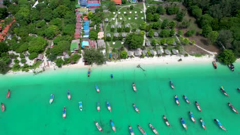 Long-Tail-Boats-Anchored-off-Koh-Lipe-Island-Thailand--Aerial-pull-back-to-reveal-island
