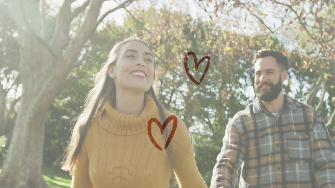 Žena natahuje ruku a drží partnerovu ruku, vede procházku parkem, povídají si, srdce bijí pro zdraví