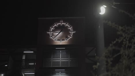 backlit analog clock on brick building