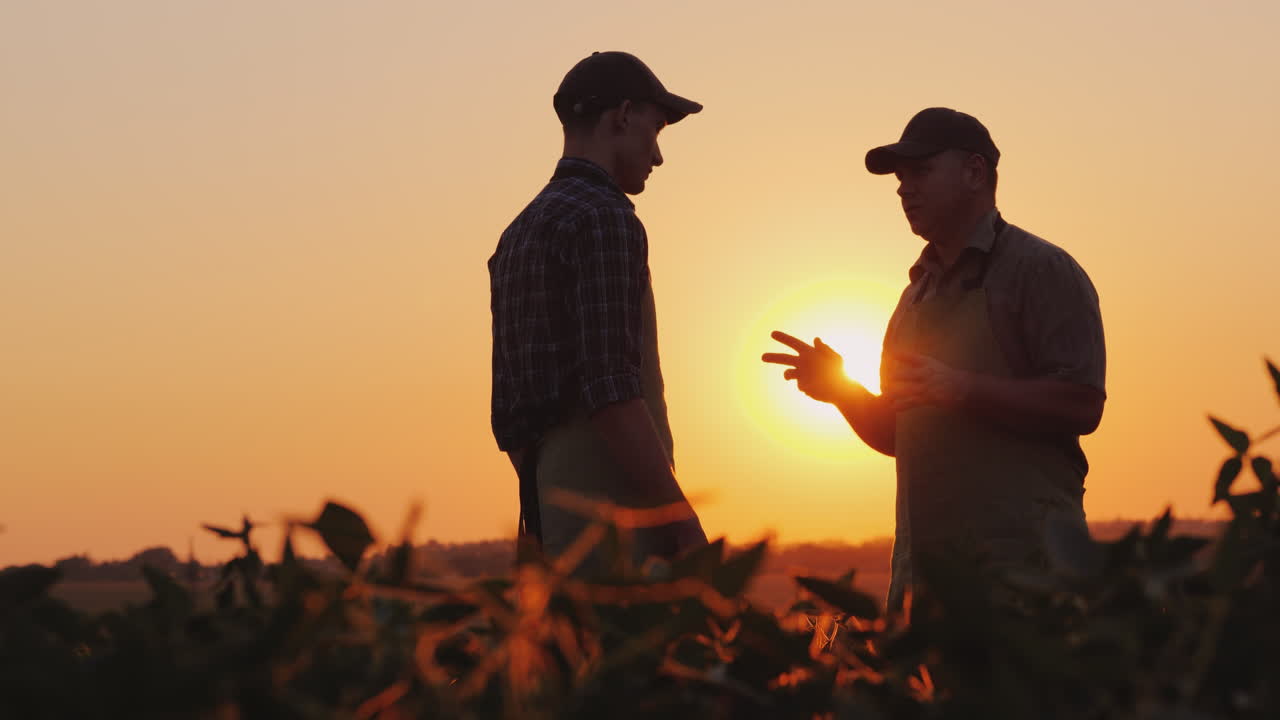 un anciano granjero le da la mano a un joven colega sonríe emociones positivas