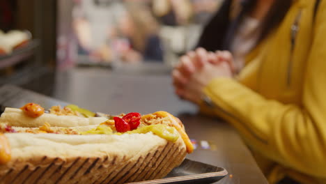 close up de los perritos calientes cocinando en el puesto del mercado de comida callejera